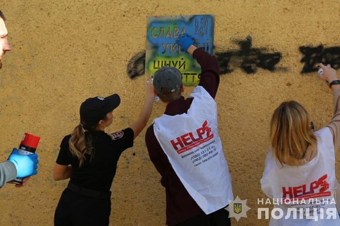 Police officers and representatives of a civic organization destroying drug graffiti in Vinnitsa