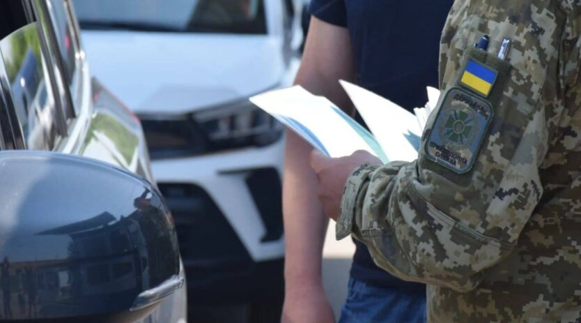 Officer checks passenger's documents at the border