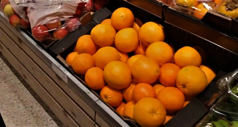 Oranges, tangerines, and bananas on the shelves