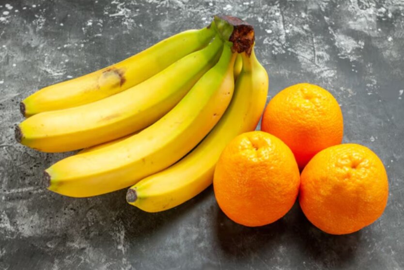 Oranges and bananas on a green background